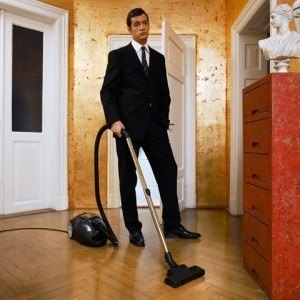 Young Man Wearing Suit Vacuuming